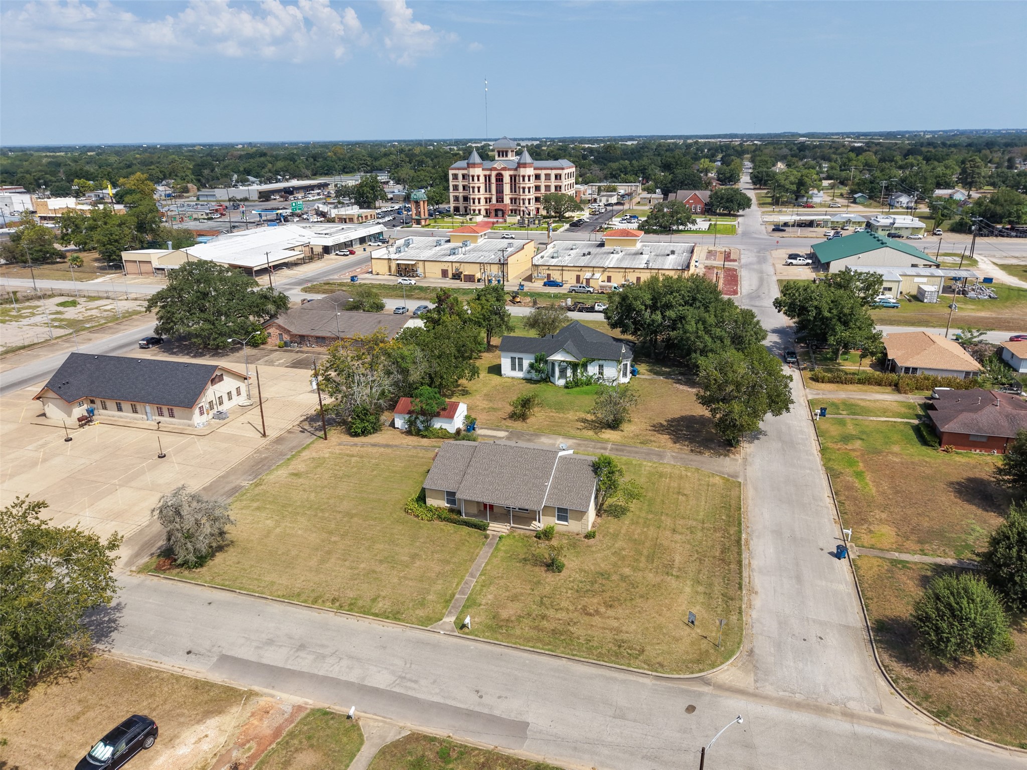 810 Main Street Hempstead, TX 77445 - Photo 29 of 32 Aerial perspective highlighting the corner lot, mature trees, and surrounding development near the heart of Hempstead.