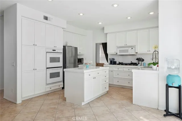 a kitchen with white cabinets and white appliances