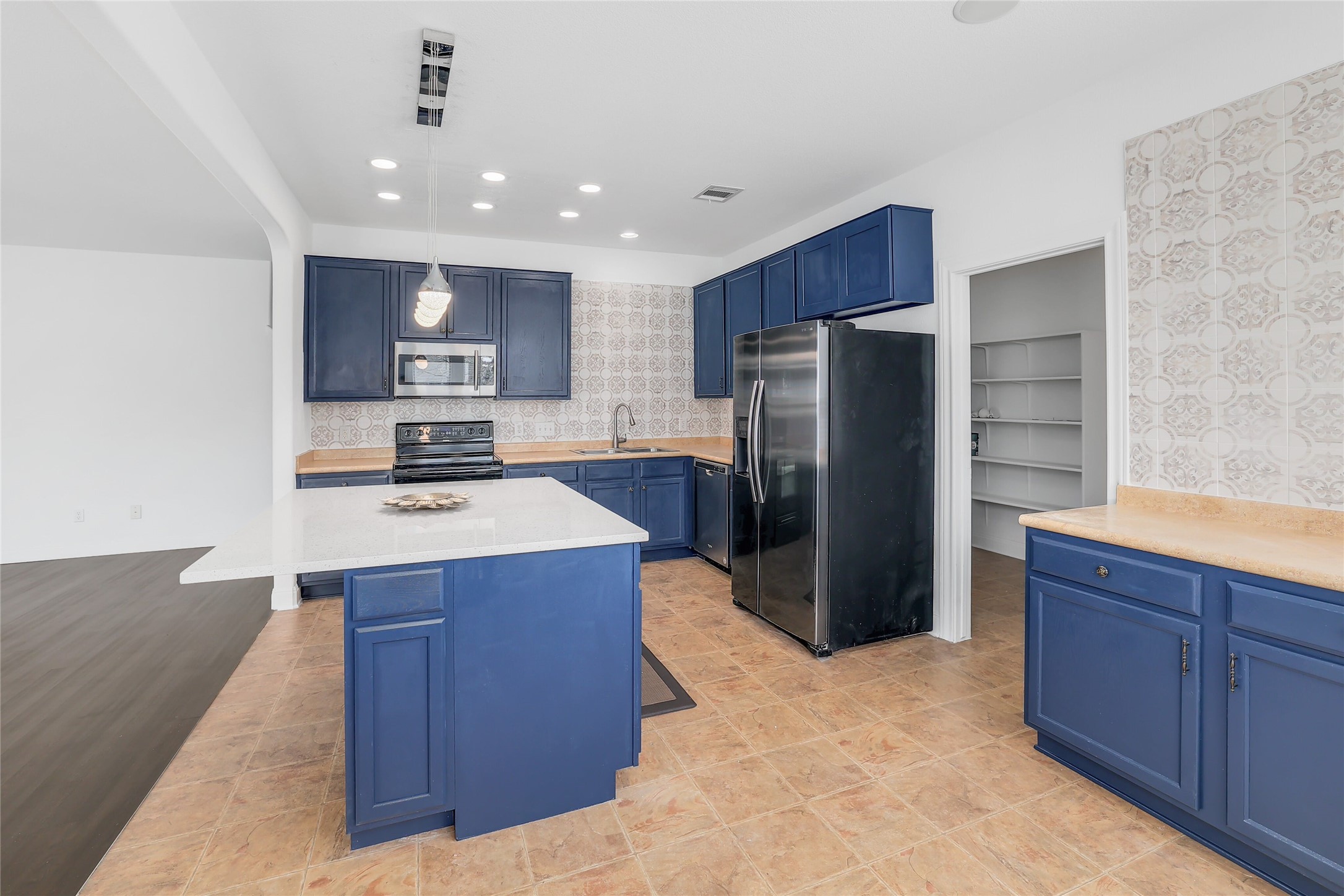 203 Ran Road Leander, TX 78641 - Photo 5 of 31 Gleaming stone countertops and classic cabinetry anchor this functional workspace alongside a walk-in pantry.