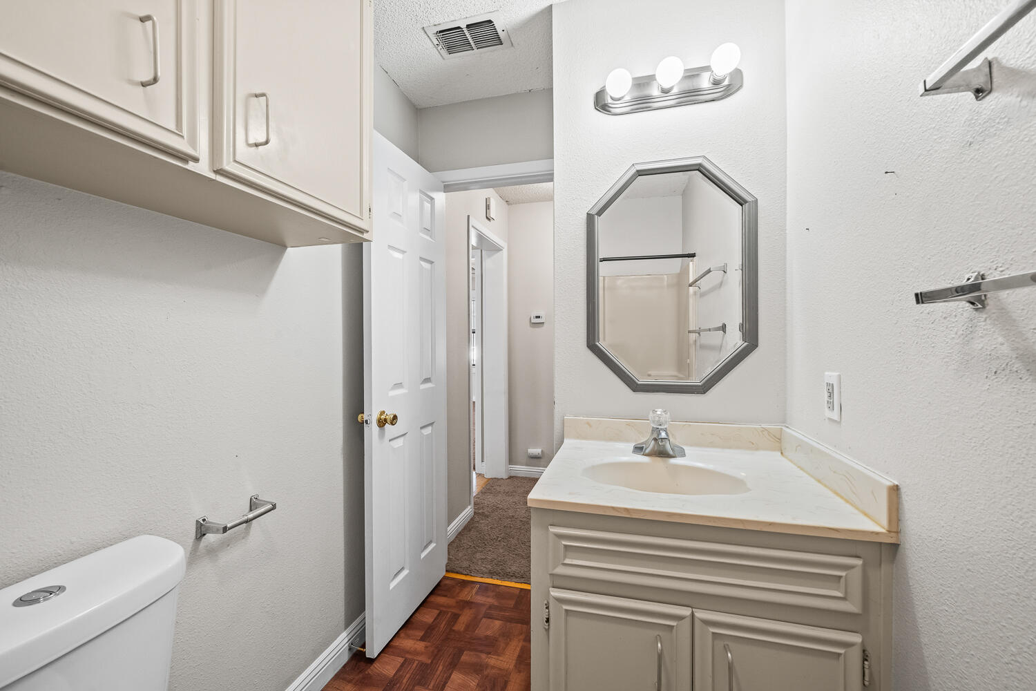 2313 20th Street Lubbock, TX 79411 - Photo 15 of 21 a bathroom with a sink a toilet and a mirror