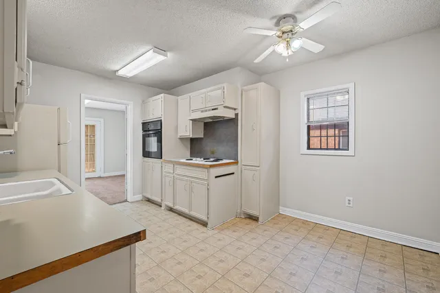 a kitchen with stainless steel appliances a sink stove and cabinets