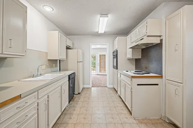 a kitchen with stainless steel appliances a sink stove and cabinets