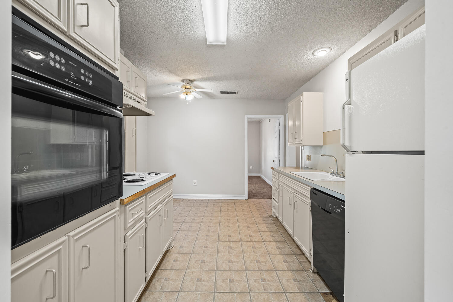 2313 20th Street Lubbock, TX 79411 - Photo 9 of 21 a kitchen with granite countertop a refrigerator and a stove top oven