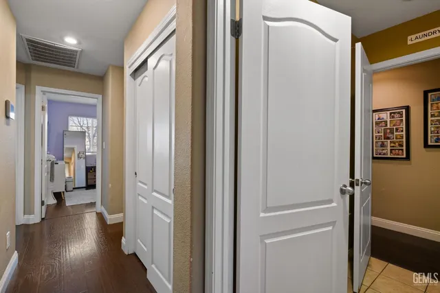 a view of a hallway with wooden floor and a bathroom