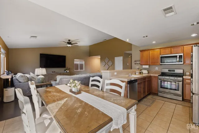 a large kitchen with stainless steel appliances granite countertop a sink and cabinets