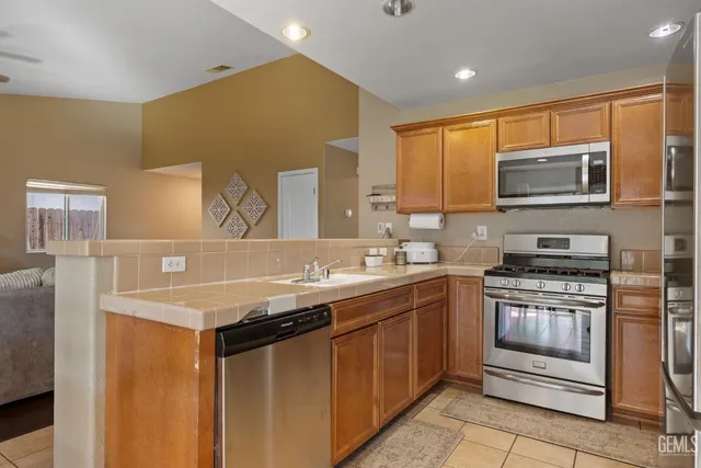 a kitchen with stainless steel appliances a stove sink microwave and cabinets