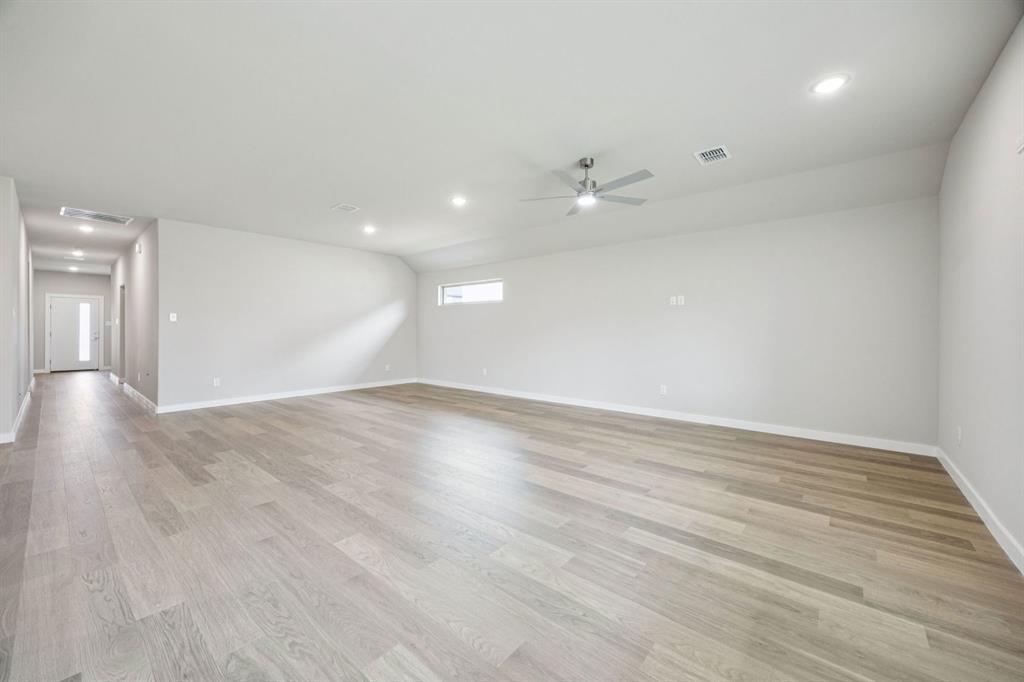 2206 Currents Road Princeton, TX 75407 - Photo 11 of 27 an empty room with wooden floor and windows