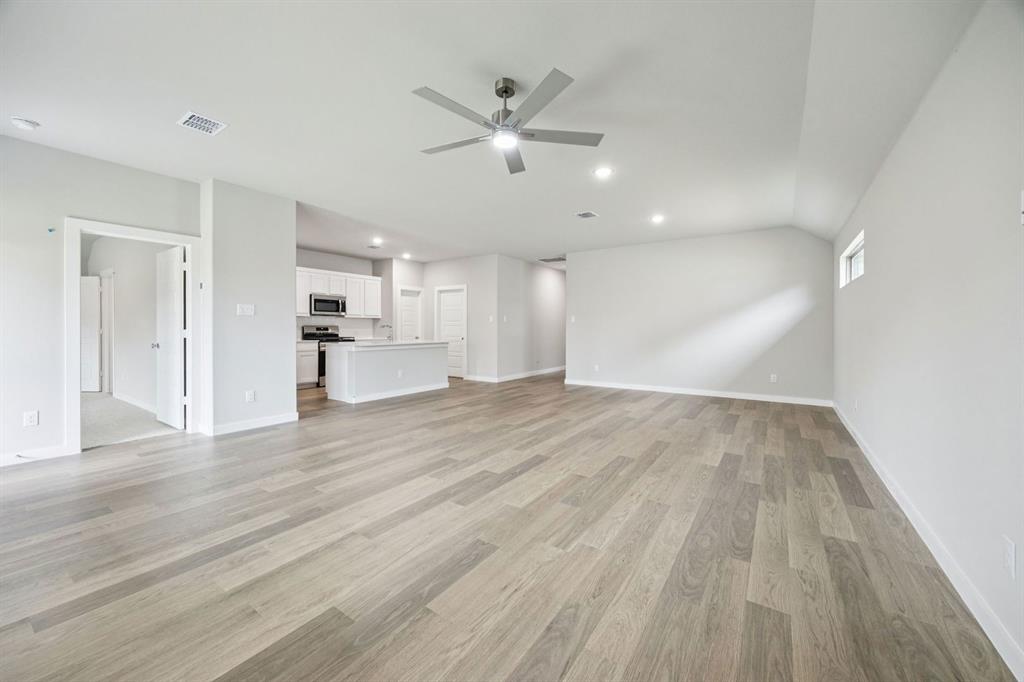 2206 Currents Road Princeton, TX 75407 - Photo 12 of 27 a view of empty room with wooden floor and ceiling fan