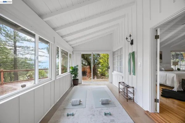 a large white room with a large window and a bed