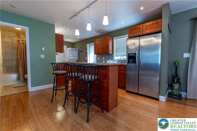 a kitchen with stainless steel appliances granite countertop a kitchen island a hardwood floor and a sink