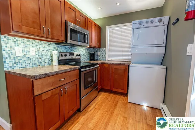 a kitchen with stainless steel appliances granite countertop wooden cabinets a stove a sink and a microwave