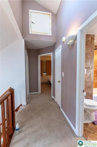 a view of a hallway with bathroom and wooden floor