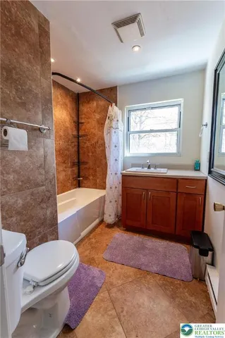 a bathroom with a bathtub sink mirror vanity and toilet