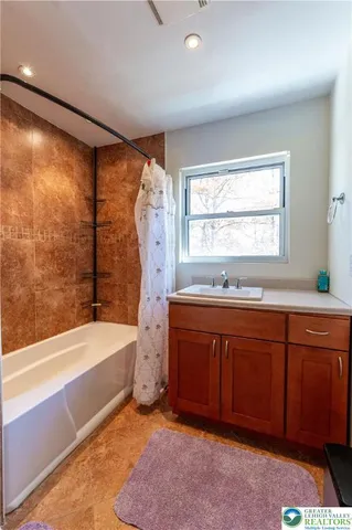 a spacious bathroom with a tub sink and mirror