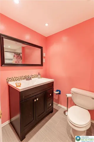 a bathroom with a toilet a sink and mirror