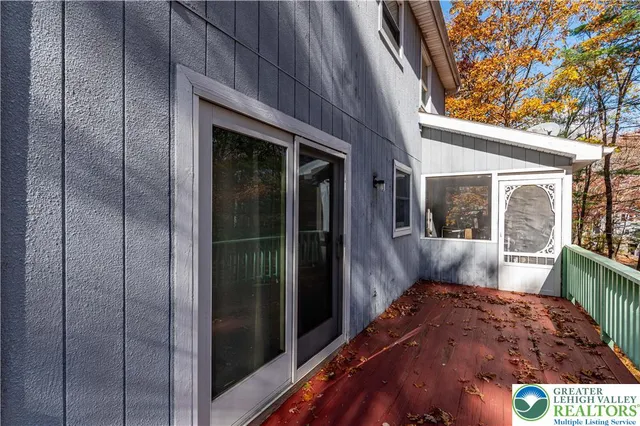 a view of a porch with a floor to ceiling window and wooden fence