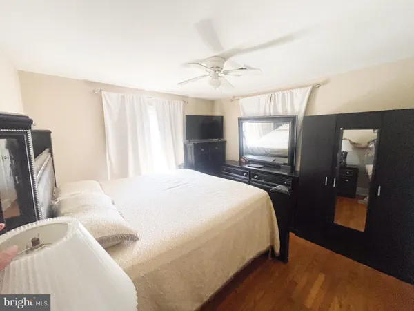 a bedroom with a bed and a flat tv screen on dresser