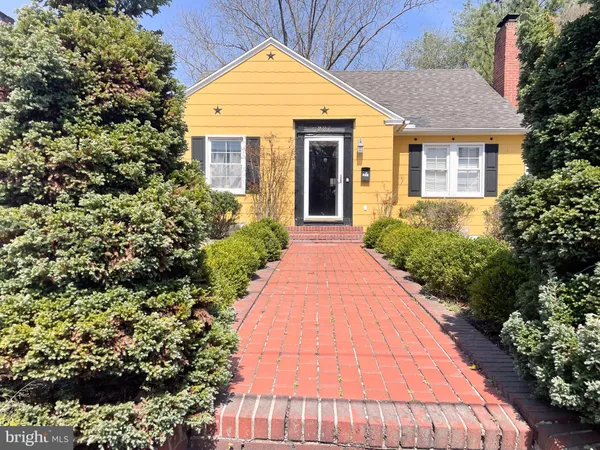a front view of a house with a yard and potted plants