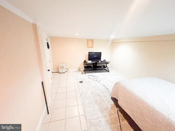 a bedroom with a bed and a lamp on dresser