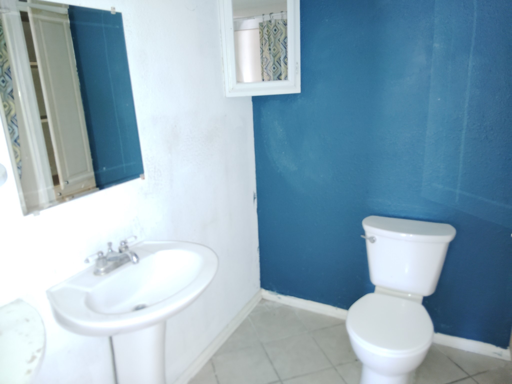903 West 8th Street Quanah, TX 79252 - Photo 6 of 15 a bathroom with a toilet sink and mirror