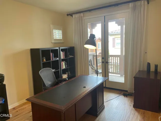a view of a hallway with wooden floor and furniture