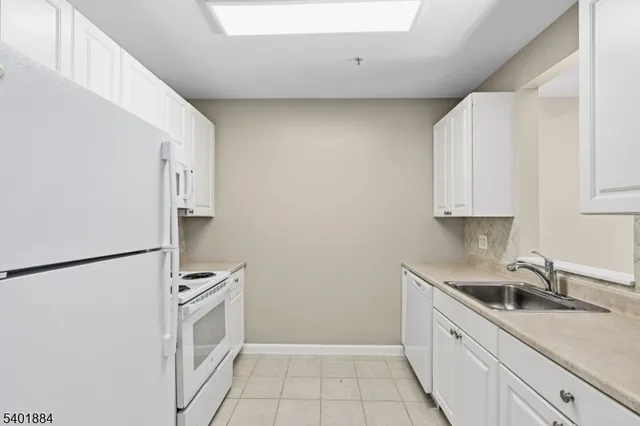a kitchen with a sink a refrigerator and cabinets
