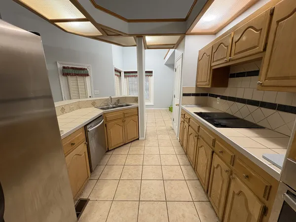 a kitchen with a sink a stove top oven and cabinets
