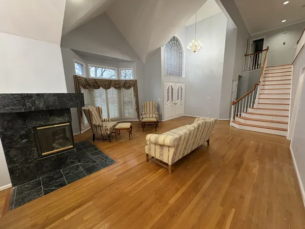 a spacious bedroom with a bed a fireplace and windows