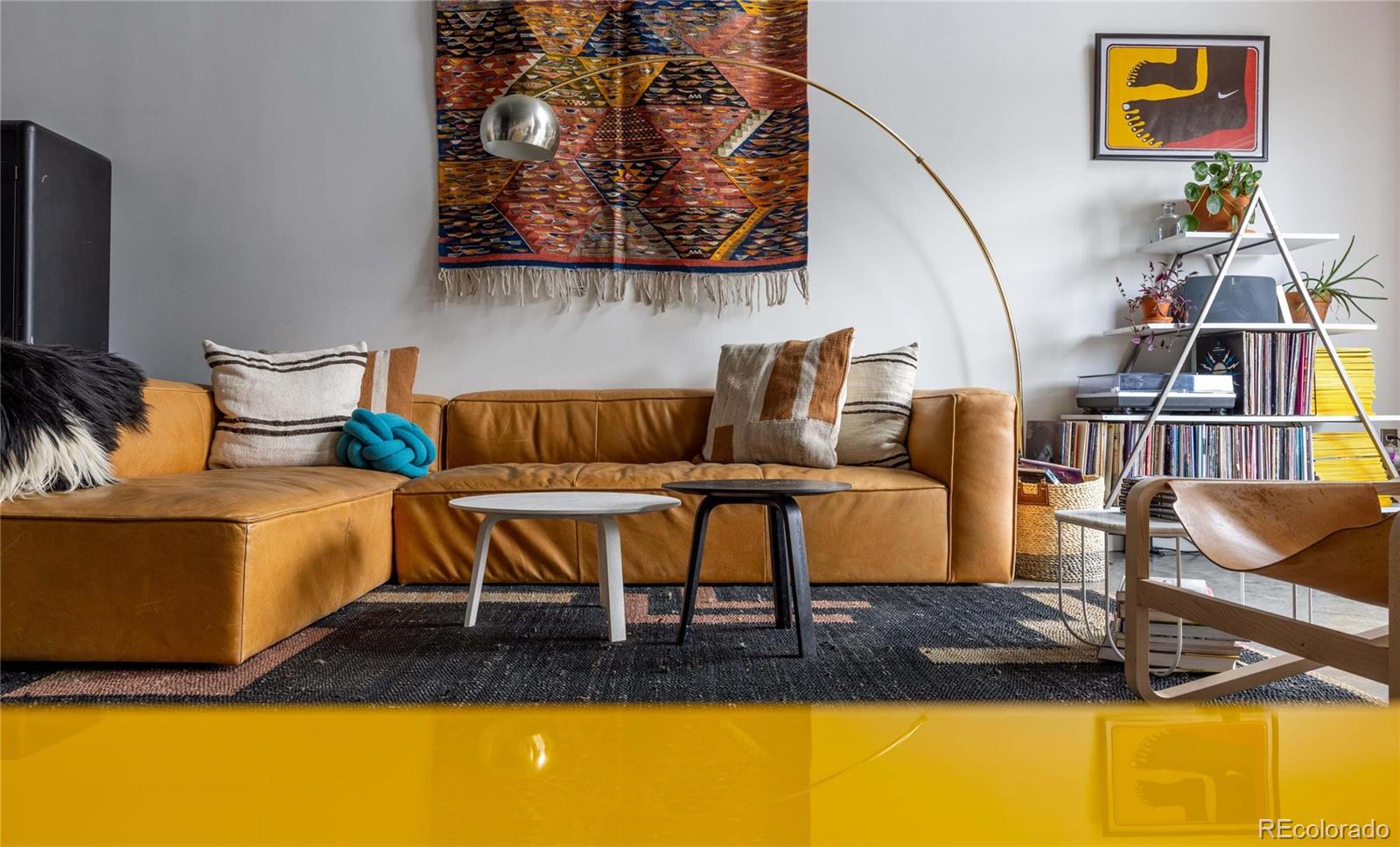 3457 Ringsby Court, Unit 306 Denver, CO 80216 - Photo 12 of 38 a living room with furniture and a flat screen tv