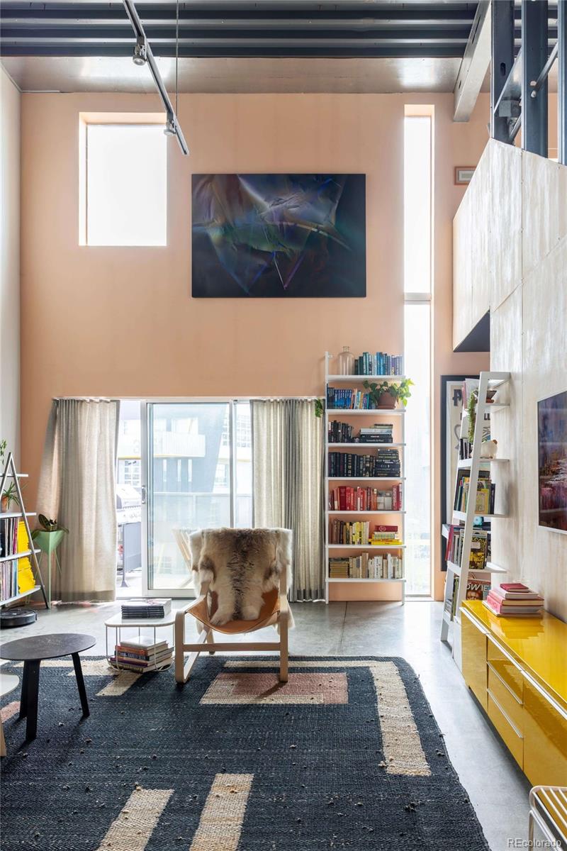 3457 Ringsby Court, Unit 306 Denver, CO 80216 - Photo 13 of 38 a living room with furniture a flat screen tv and large window