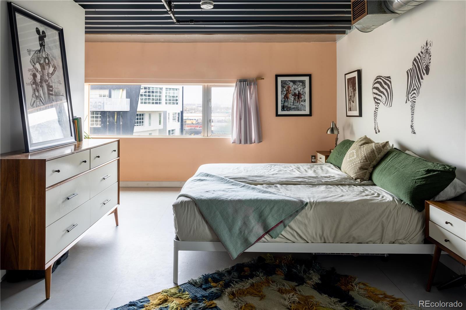 3457 Ringsby Court, Unit 306 Denver, CO 80216 - Photo 23 of 38 a bedroom with a bed and a window