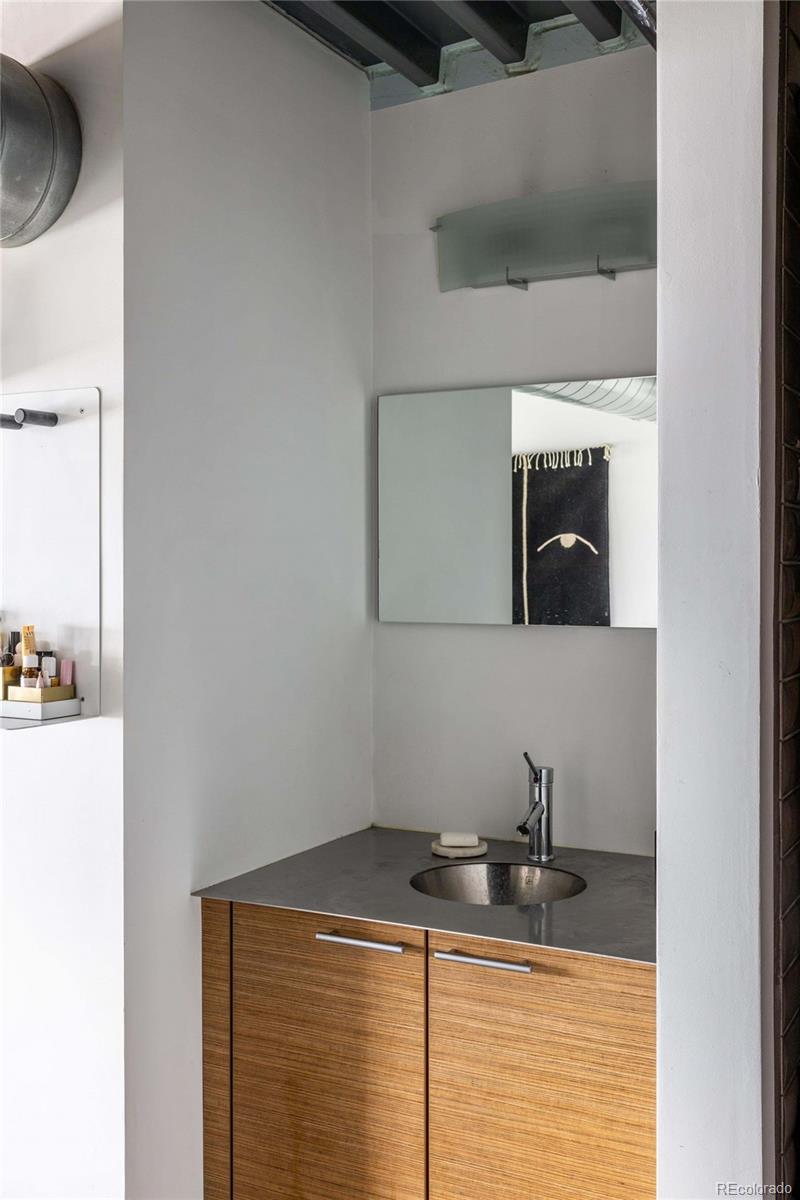3457 Ringsby Court, Unit 306 Denver, CO 80216 - Photo 24 of 38 a bathroom with a granite countertop sink and a mirror