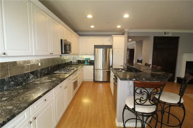 a large kitchen with stainless steel appliances granite countertop a sink and cabinets