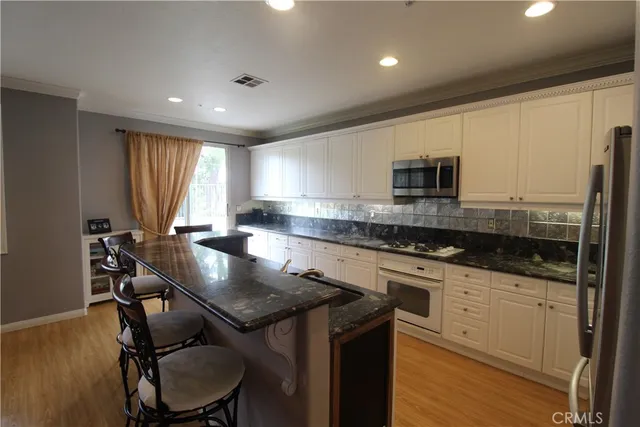 a kitchen with a table chairs sink and cabinets