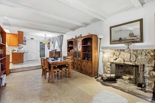 a view of a dining room with furniture a fireplace and chandelier