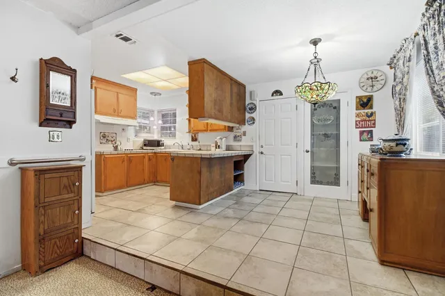 a kitchen with stainless steel appliances kitchen island granite countertop a refrigerator and a stove top oven