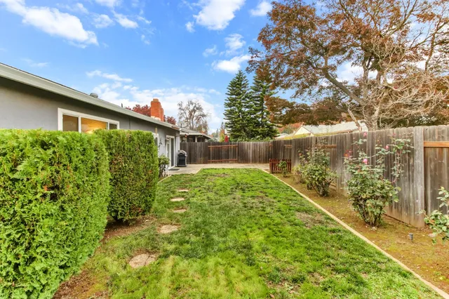 a front view of a house with a yard and a garden