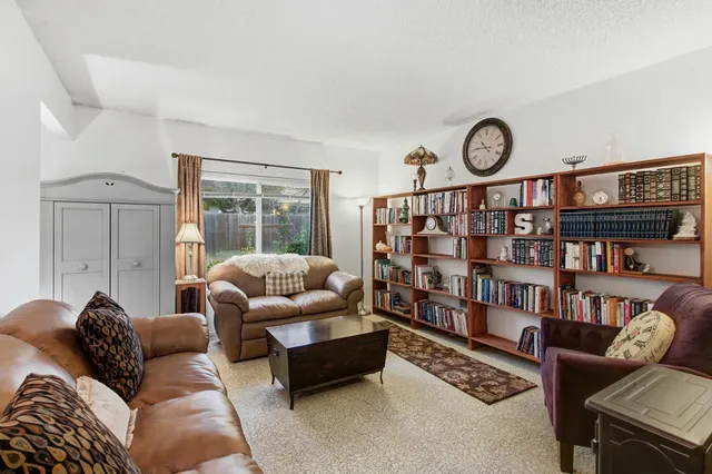 a living room with furniture and a book shelf