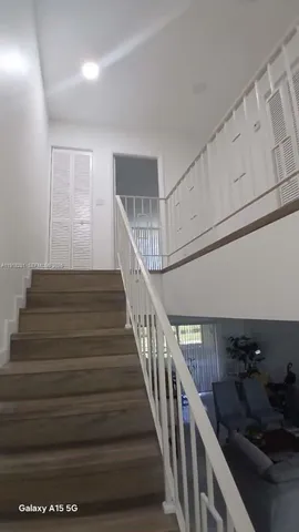 a view of a hallway with wooden floor and stairs