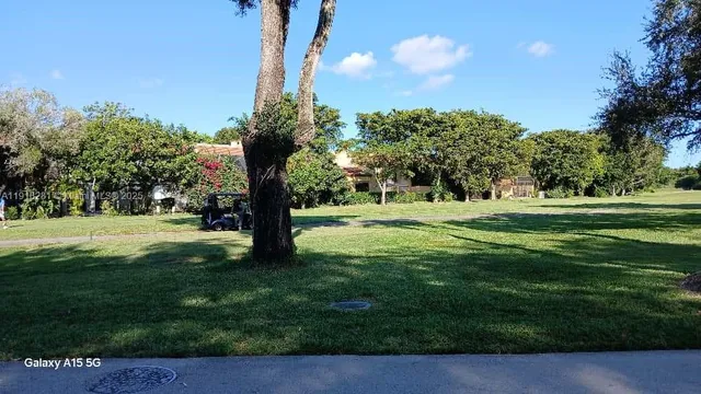 a kitchen with kitchen island granite countertop a sink and a refrigerator