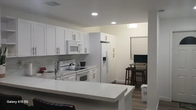 a kitchen with a sink cabinets and wooden floor