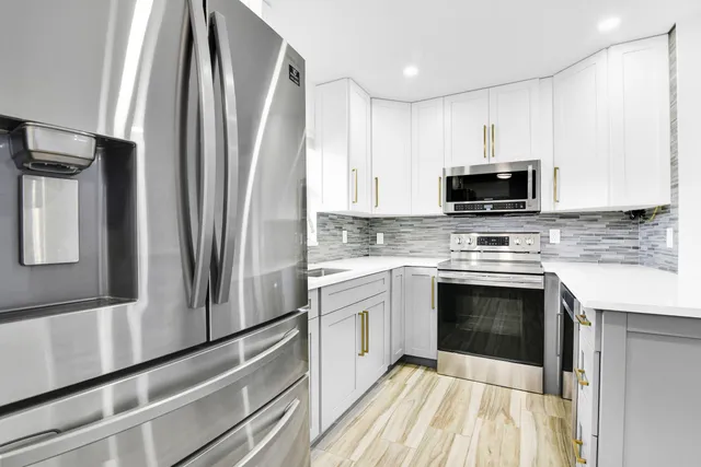 a kitchen with stainless steel appliances a stove sink and microwave
