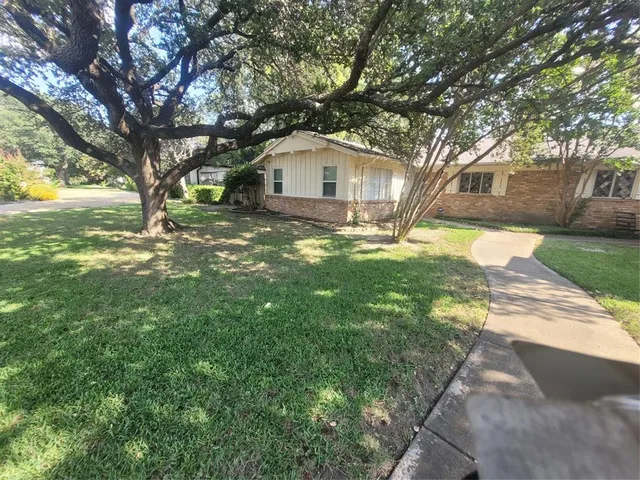 a front view of a house with yard and green space
