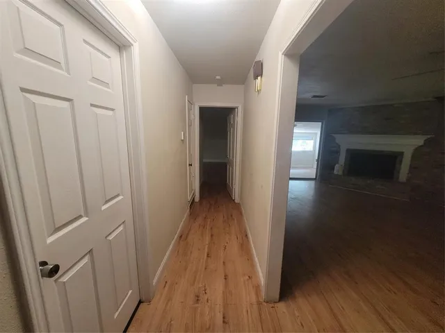 a view of a hallway with wooden floor and staircase