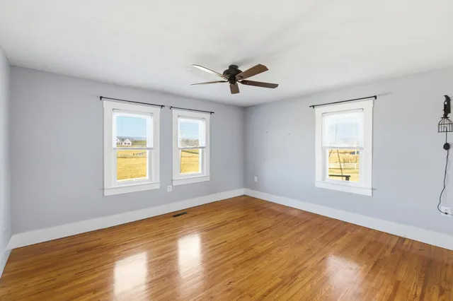a view of empty room with wooden floor
