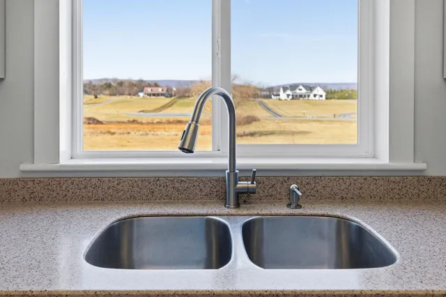 a kitchen with a refrigerator a sink and wooden floor