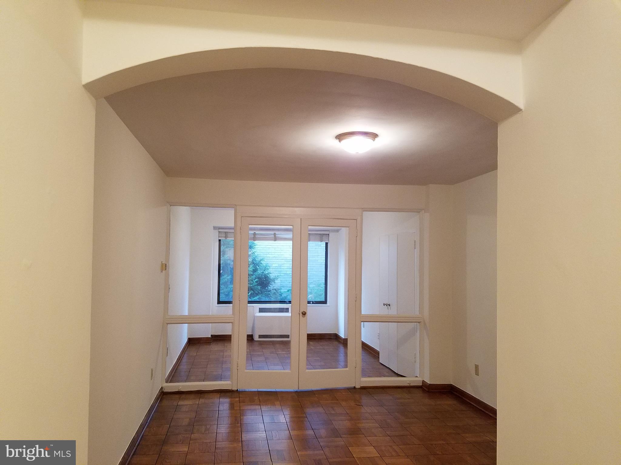 1 Scott Circle Northwest, Unit 102 Washington, DC 20005 - Photo 11 of 17 an empty room with wooden floor and windows