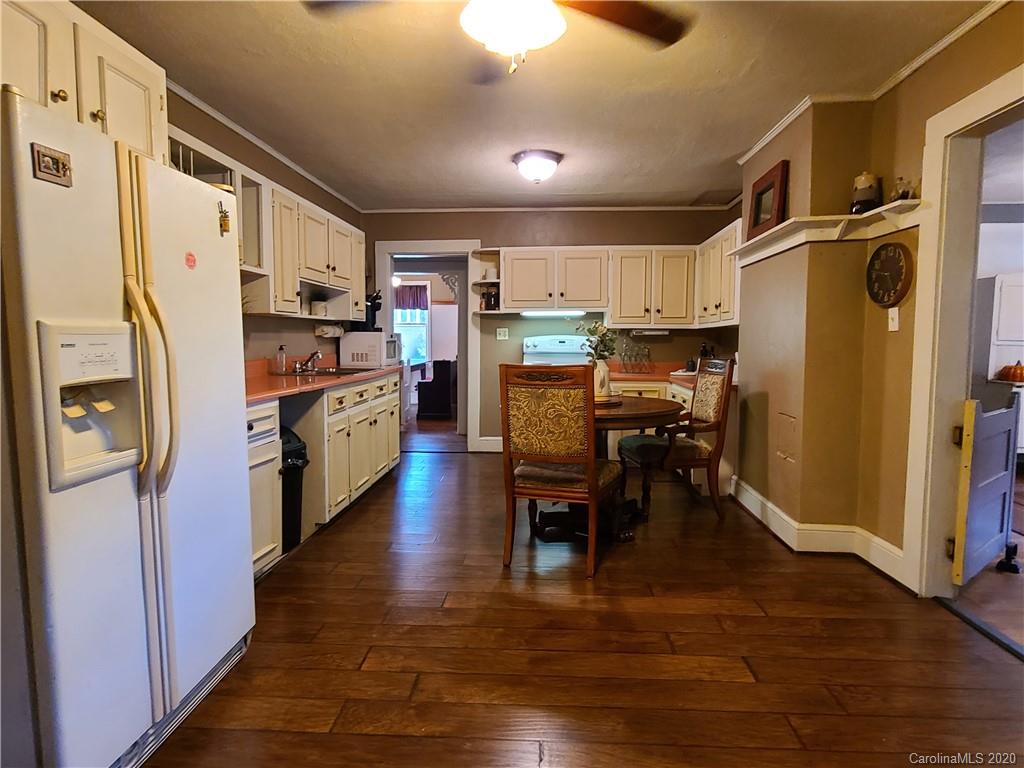 26 Jones Road Leicester, NC 28748 - Photo 17 of 34 a kitchen with stainless steel appliances a refrigerator a stove top oven a sink dishwasher and a dining table with wooden floor