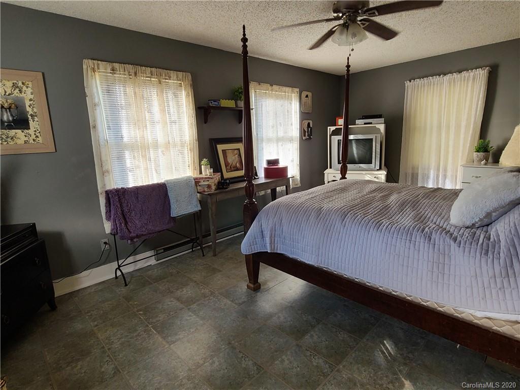 26 Jones Road Leicester, NC 28748 - Photo 18 of 34 a bedroom with a bed a chandelier and flat screen tv