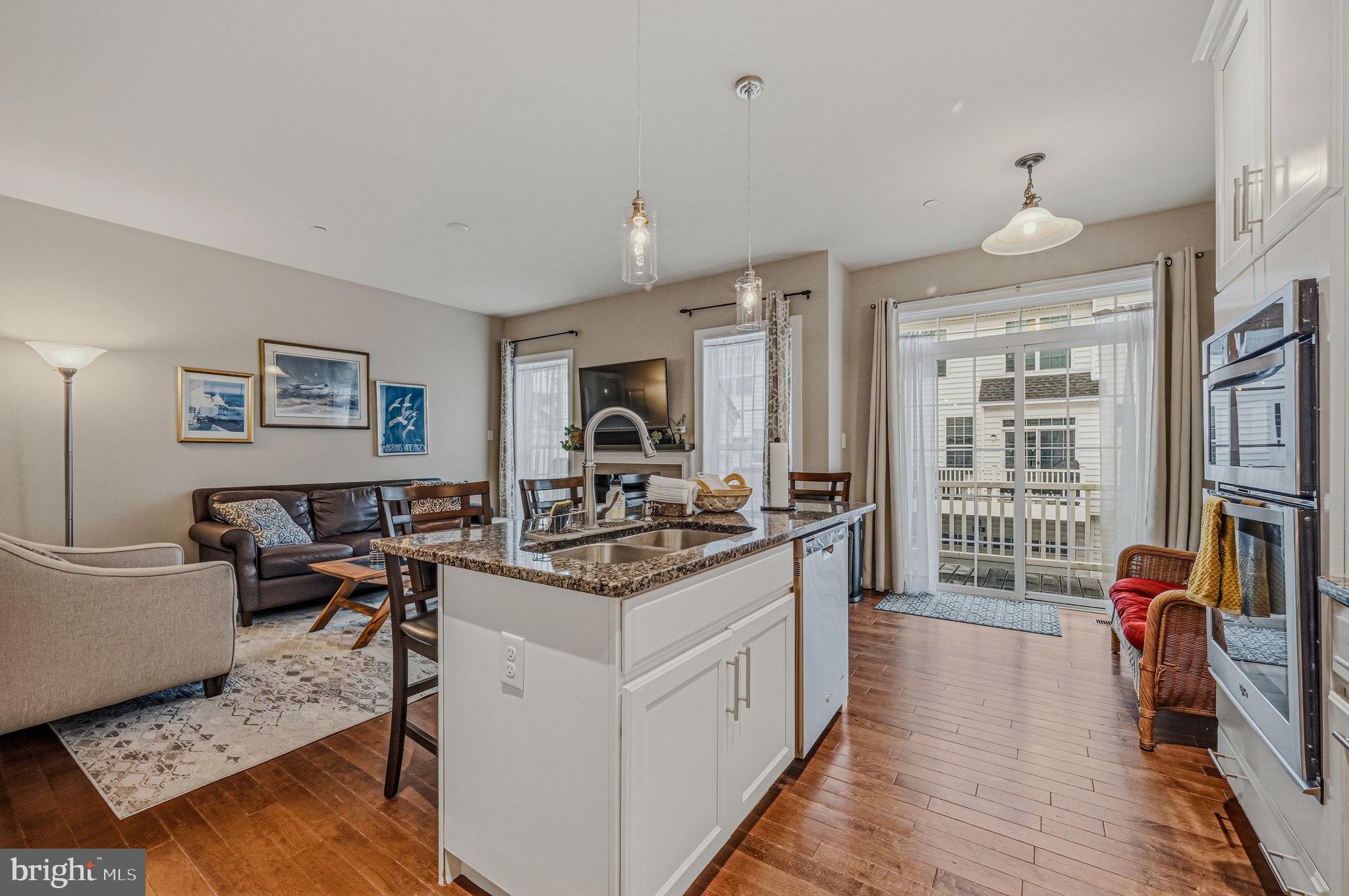 208 Jackdaw Alley, Unit 208 Springfield, PA 19064 - Photo 14 of 43 a view of living room kitchen with furniture and wooden floor